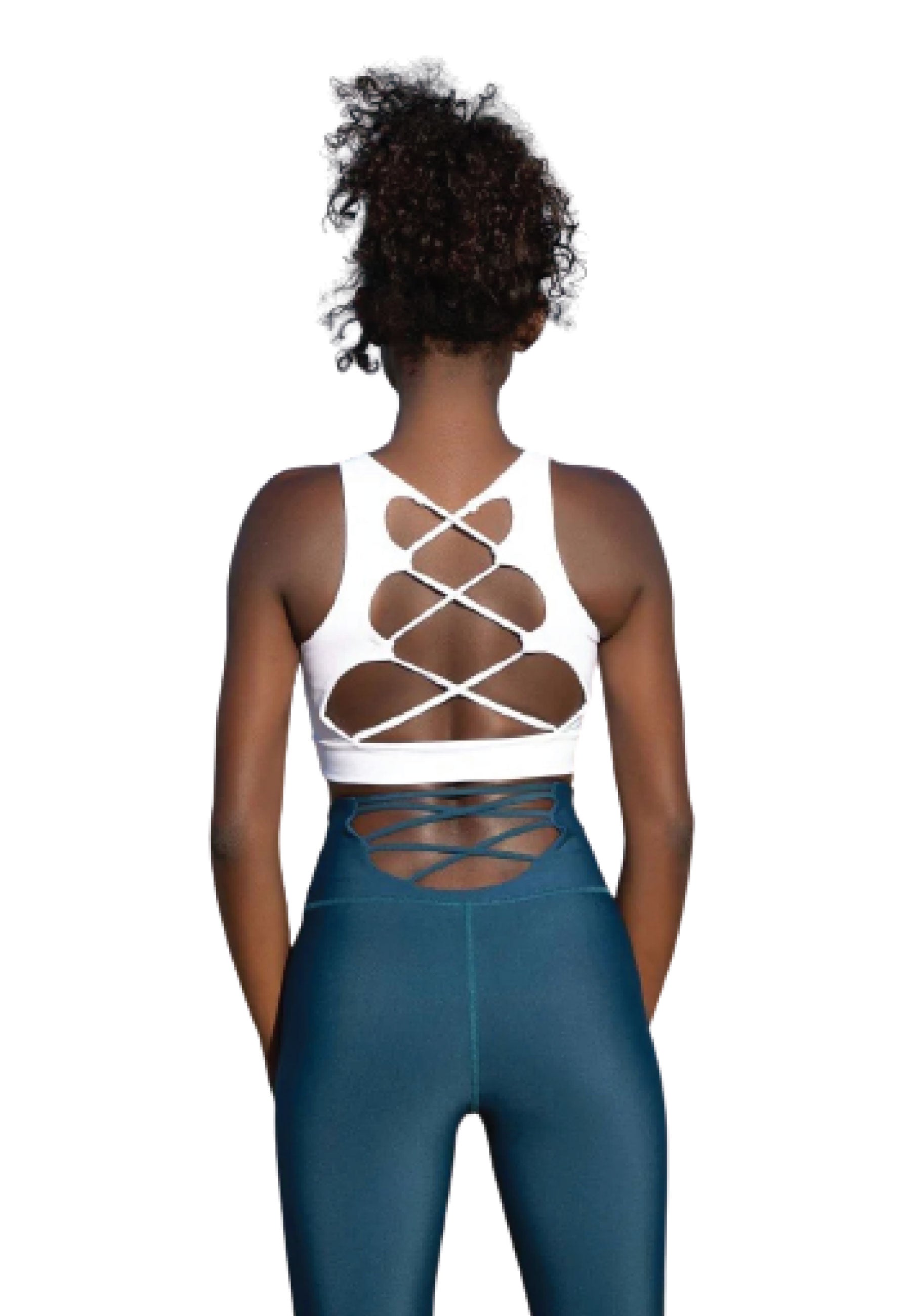 Person im gestreiften Sport-BH 150 von Lismina in Weiss und blauen Leggings, die vor einem weißen Hintergrund steht.